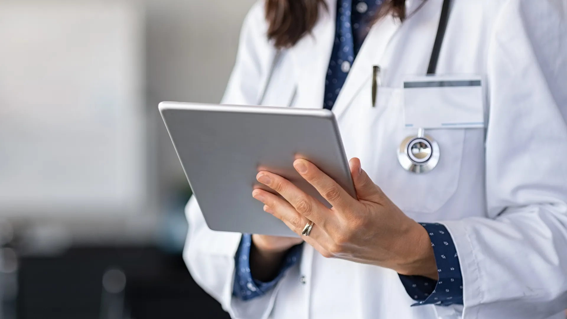 Healthcare workers reviewing patient records on a tablet